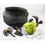 A large cast iron cauldron, on a tri-pod base and with wrought handle,