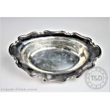 An Edwardian silver dish, Atken Brothers, Sheffield 1907, the oval bowl with shaped cusped rim,