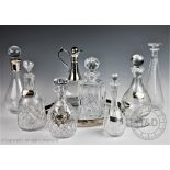 A collection of eight decanters and stoppers to include, a silver collared example,