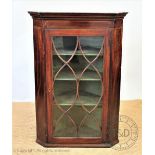 A George III inlaid mahogany hanging corner cabinet, with astragal glazed door,