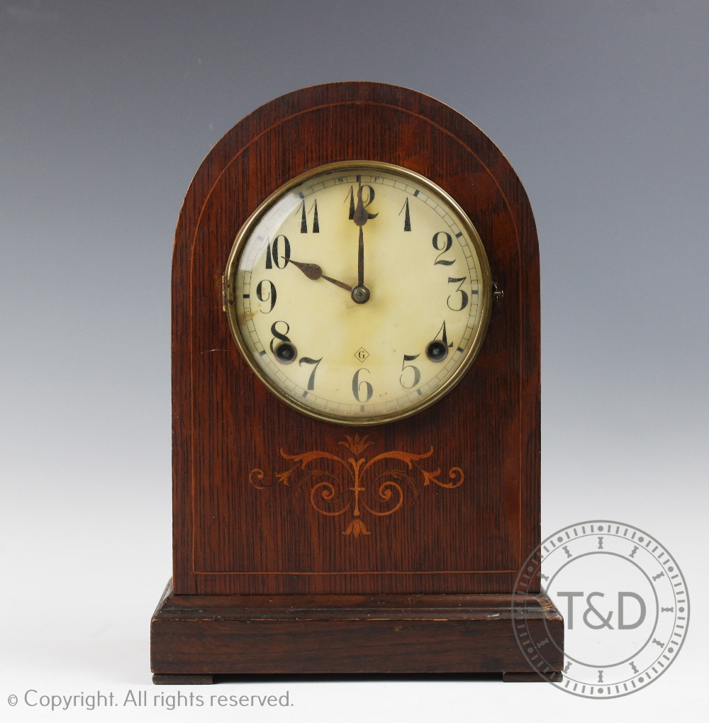 An early 20th American inlaid oak dome top mantel clock, with Arabic dial.