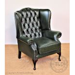 A library wing arm chair, with button back green leather upholstery, on cabriole legs,