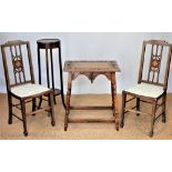 A carved oak side table, 71cm H x 61cm x 43cm D, with two Edwardian inlaid mahogany bedroom chairs,