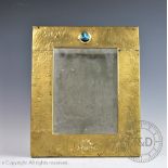 An Arts & Crafts brass mounted mirror in the manner of Liberty & Co,