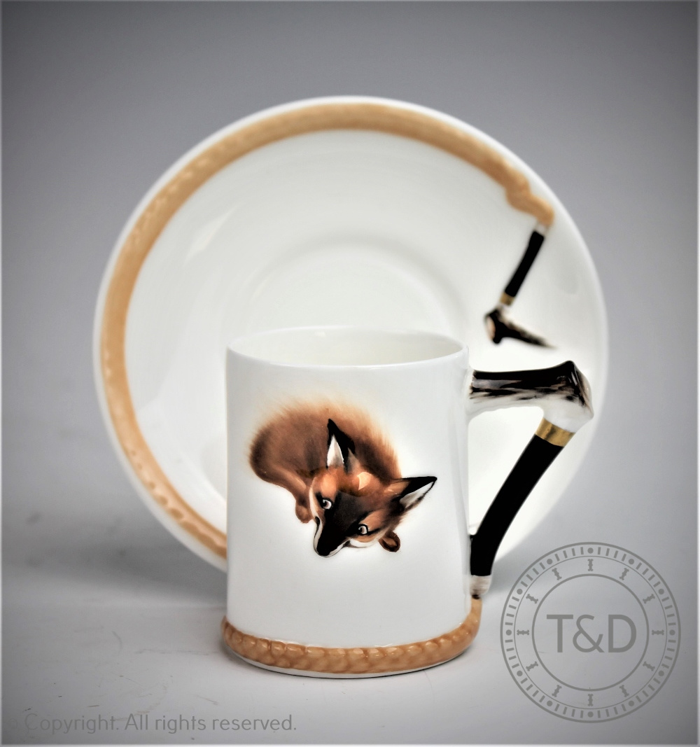 A Royal Doulton H4927 Hunting teacup and saucer, modelled in relief with a fox and riding crop,