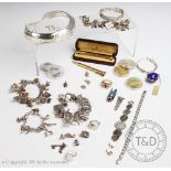 A collection of four silver coloured and silver charm bracelets, hung with numerous charms,