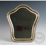 A silver mounted mirror, Sheffield 1972, the shaped cushion framed mirror with embossed floral's,