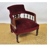 A late Victorian carved walnut salon tub chair, on turned legs,