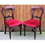 A set of four Victorian carved walnut dining chairs, with shaped backs and upholstered seats,