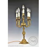 A Rococo style cast bronzed candelabra, modelled on a scroll base supporting five branches,