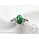 A jade and diamond ring, designed as a central cabochon jade,