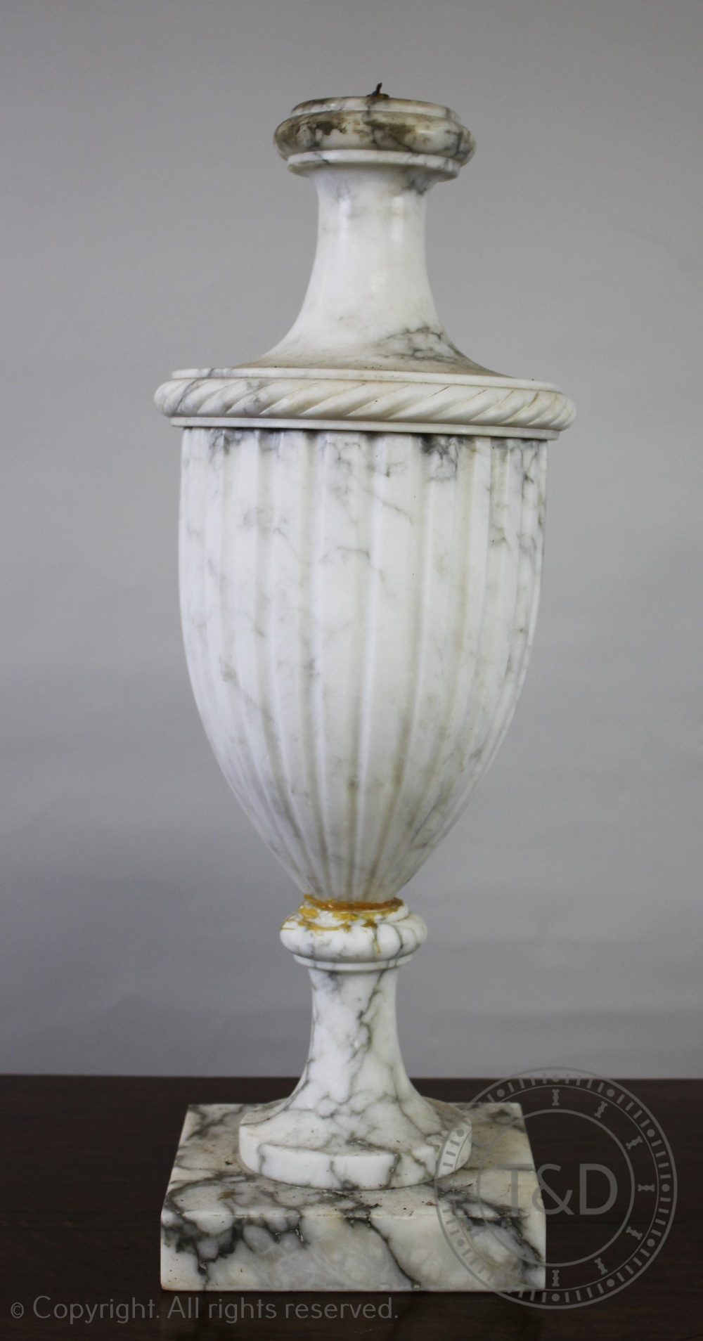 A Neo-classical veined white marble lamp, of fluted urn form, on square base,