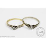 Two diamond solitaire rings, each claw set and with diamond set shoulders,