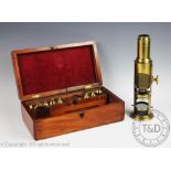 A late 19th century lacquered brass field microscope, with ratchetted lens,