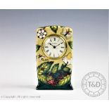 A Moorcroft mantel time piece, decorated with a strawberry plant and insects, 16cm,