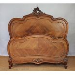 A French carved walnut bed of Louis XV style, with serpentine head board and foot boards,