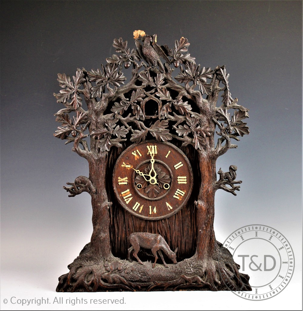 A later 19th century Black Forest carved wood twin fusee cuckoo clock,