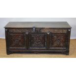 A 17th century and later carved oak coffer, with panelled front, on bracket feet,