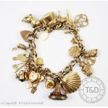 A 9ct gold curb link bracelet hung with numerous charms, to include; a stork holding a baby,