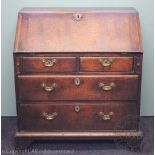 A George III oak bureau, with fall enclosing a fitted interior, over two short and two long drawers,