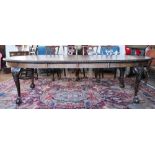 A 1920's carved mahogany extending dining table and set of ten chairs,