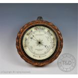 An Edwardian Mappin & Webb Ltd barometer, with circular carved oak case and bevelled glass,