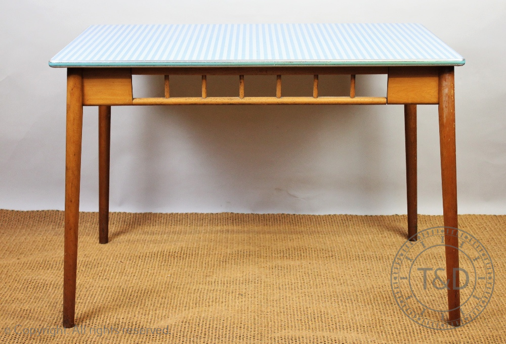 A late 1950's retro beech kitchen table, gingham style top with a metal trim, on tapered legs,