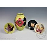 A Moorcroft Anemone pattern vase, decorated with flowers against a yellow / green ground,