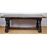 An 18th century style oak refectory table, of a rustic appearance, panelled top with cleated sides,