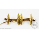 A pair of cufflinks converted to a brooch, stamped verso '15ct', attached safety chain,