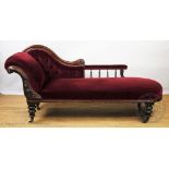 A Victorian carved walnut chaise longue, with button back red upholstery and scroll frame,