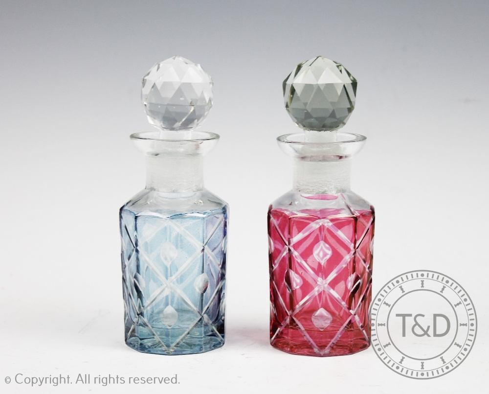 Two cut glass scent bottles and stoppers, one with a pink tint the other with a blue tint,