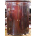 A George III inlaid mahogany bow front hanging corner cabinet,