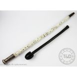 A Chinese white metal topped fish style vertebrae walking cane, 65cm,