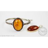 An amber set pendant, of oval form and set in 9ct yellow gold, London 2004,
