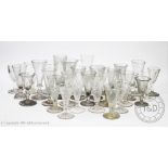 A collection of drinking glasses, mostly conical flute types,