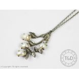 A pearl set foliate pendant,