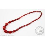 A cherry amber bead necklace, designed as thirty four graduated beads, gross weight 42.