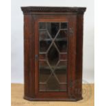 A 19th century oak hanging corner cabinet, with astragal glazed door,