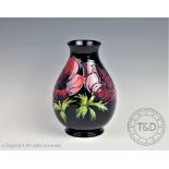 A Moorcroft Anemone pattern vase, decorated with flowers against a deep blue ground,