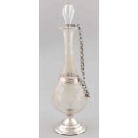 Nicely etched vial with bunches of grapes placed on a silver round base with pearl border with