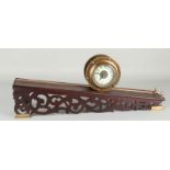 Old brass Rolling Ball Clock on wood-stuck console. Size: 25 x 55 x 12 cm. In good condition.
