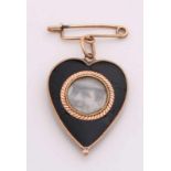 Pin with heart pendant made of black stone with yellow gold edge and medallion. 21x22mm. Pin is