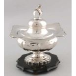 Silver tobacco pot, 833/000, rectangular model with an oval shaped foot on a wooden base. With