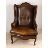 Old leather armchair with brown leather and wood-stained edges. Second half of the 20th century.