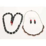 Two necklaces with black stones and a pair of earrings with cut black stones. Zwei Halsketten mit