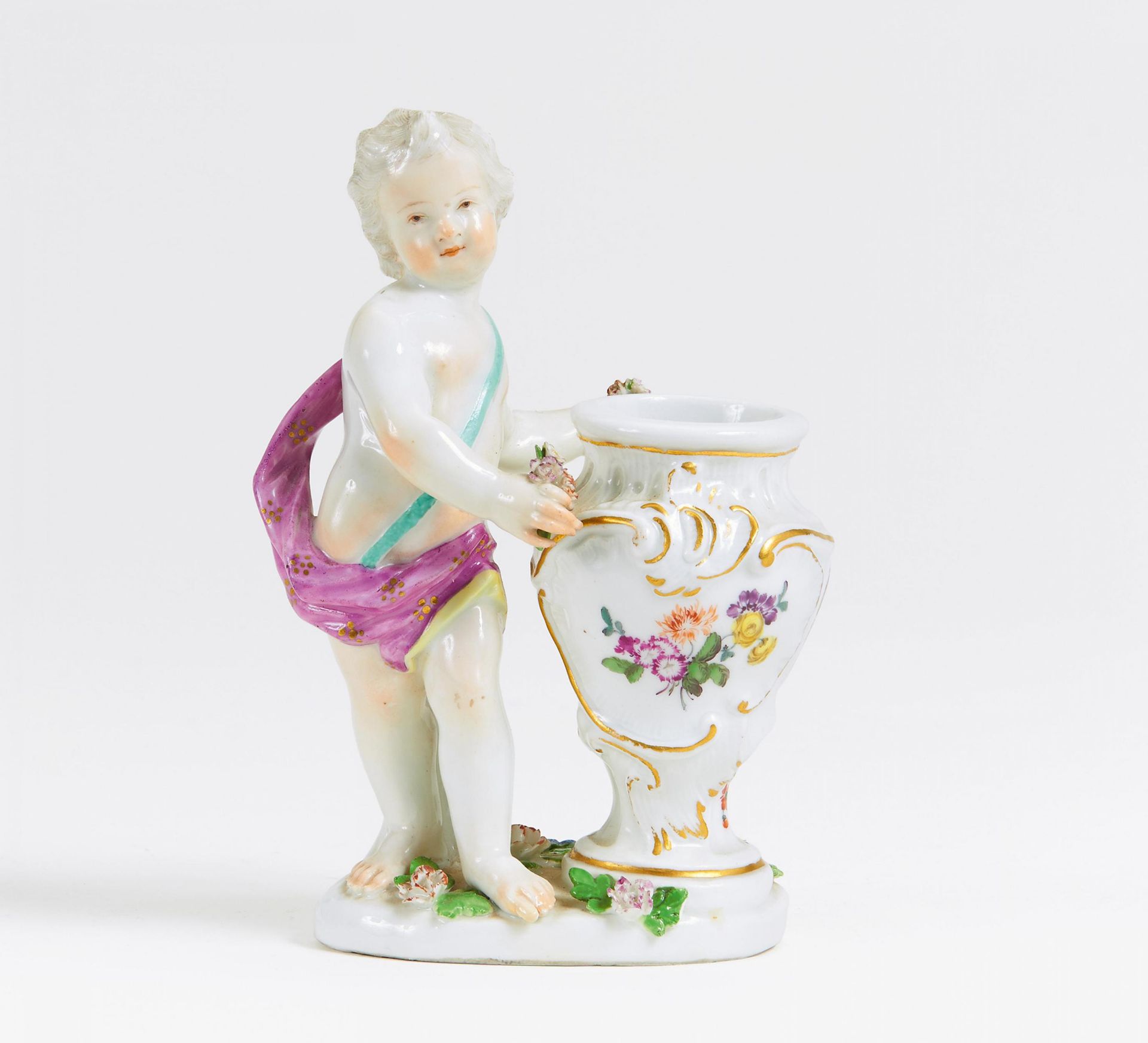 KLEINER PUTTO MIT VASE. Meissen. Porzellan, farbig und gold staffiert. H.13,5cm. Ohne erkennbare