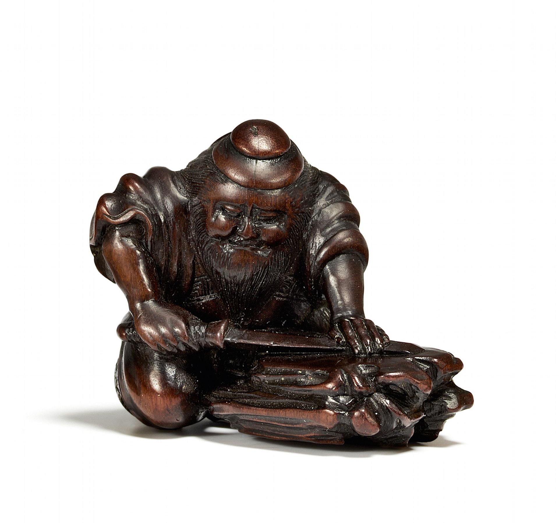 NETSUKE: SHÔKI SCHLEIFT SEIN SCHWERT. Japan. Edo-Zeit. 19. Jh. Dunkelbraunes Obstholz. Shôki