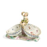 KLEINER TAFELAUFSATZ MIT PUTTO. Meissen. 18.Jh. Porzellan, farbig und gold staffiert. Höhe 17cm.