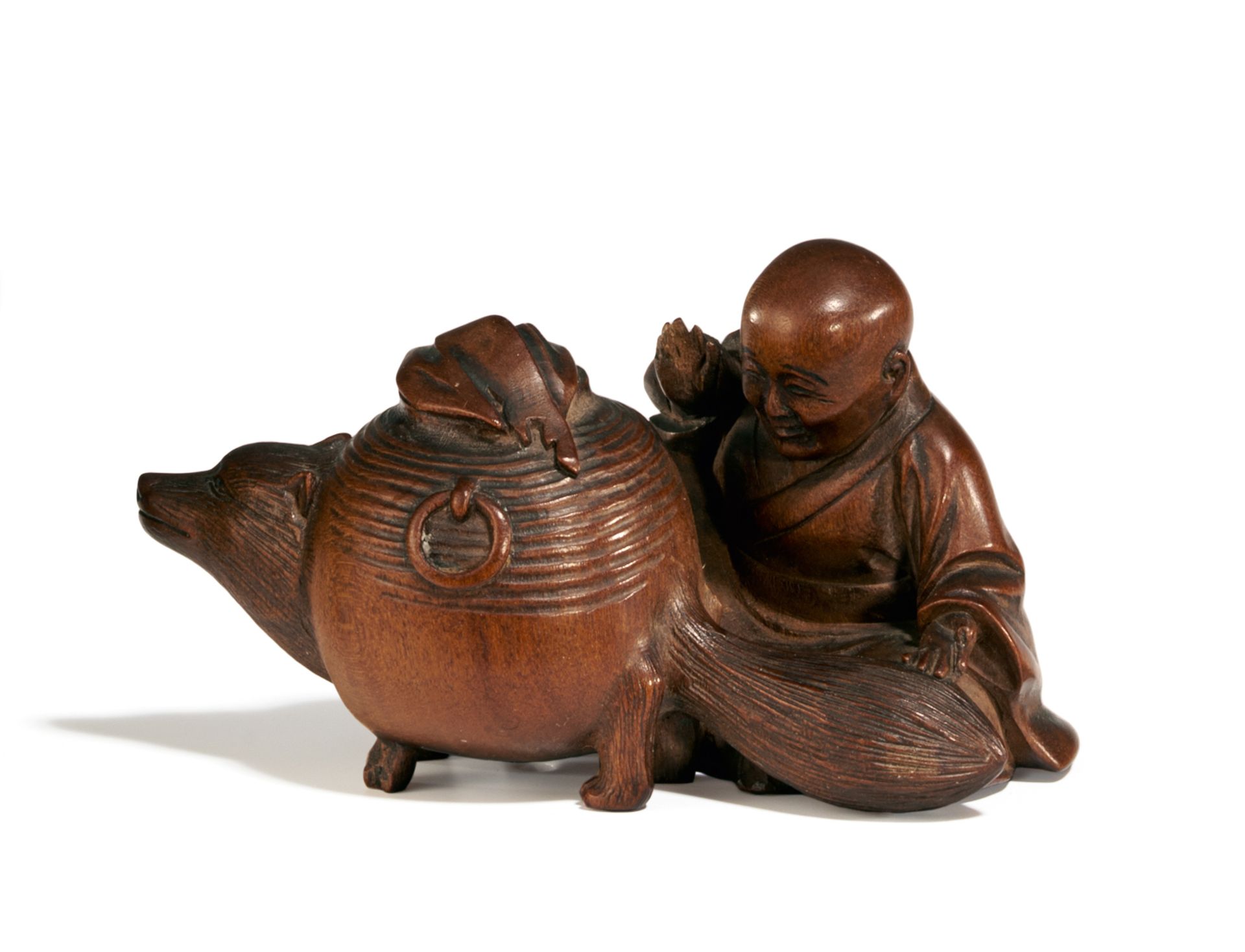 NETSUKE: BUMBUKU-CHAGAMA. Japan. 19. Jh. Buchsbaum, dunkel eingefärbt. Es erzählt die Geschichte